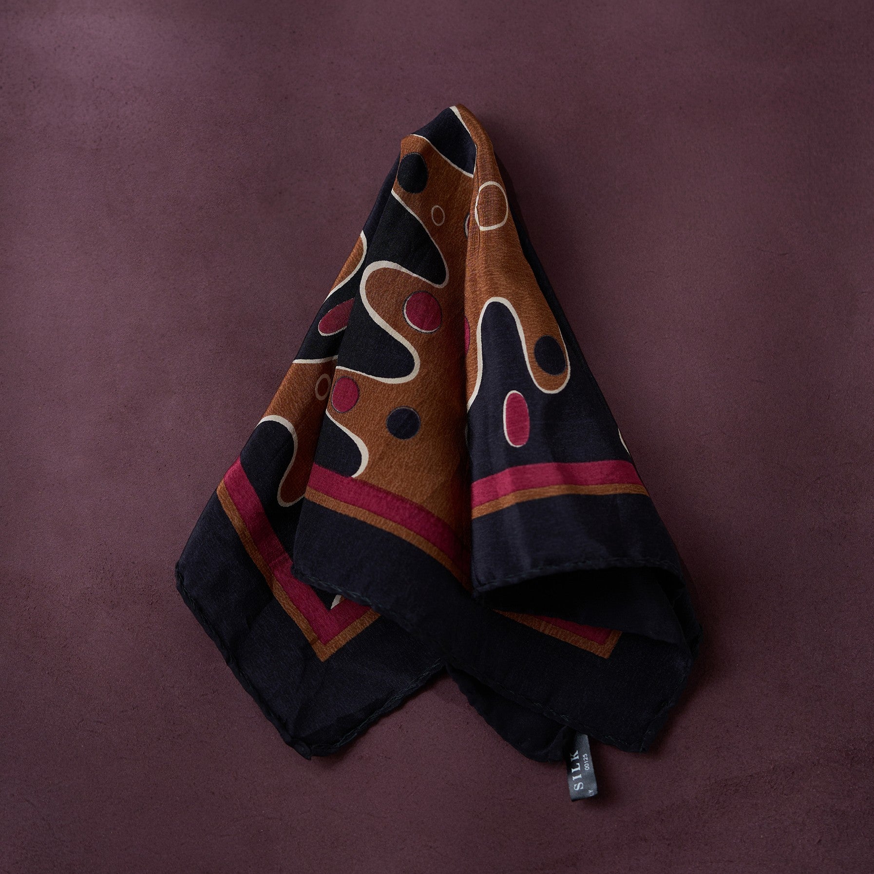 Folded fabric with abstract pattern on a purple background