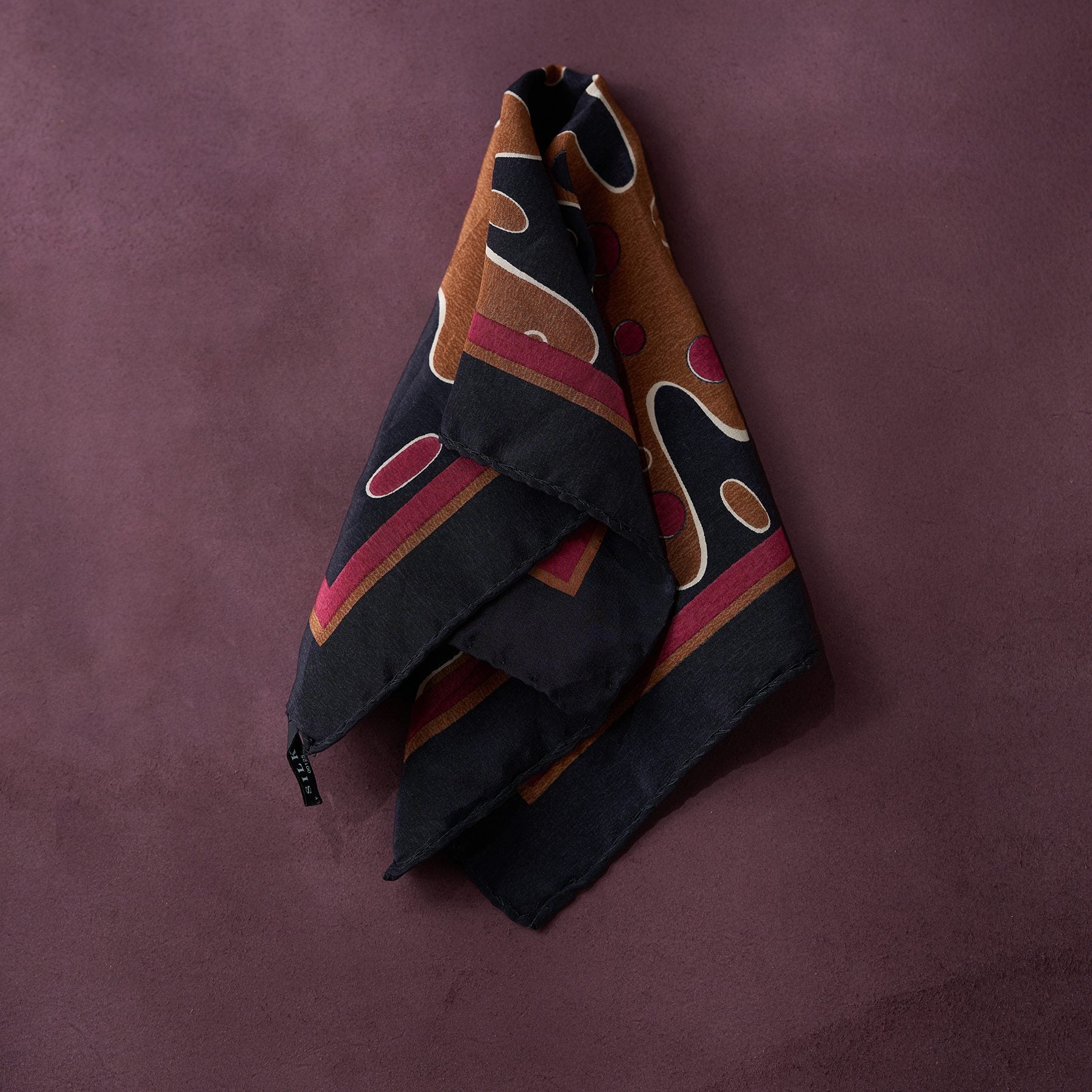 Folded fabric with geometric pattern on a purple background