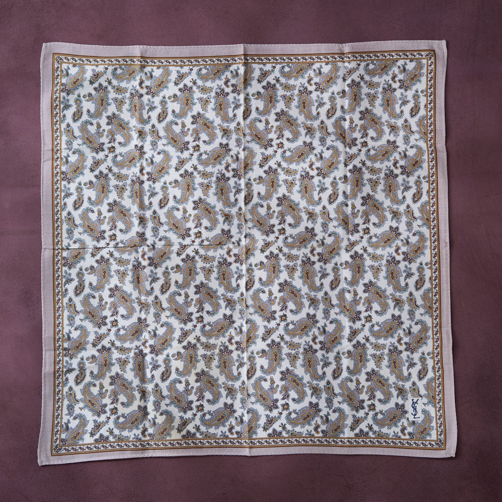 Fabric with a paisley pattern on a maroon background