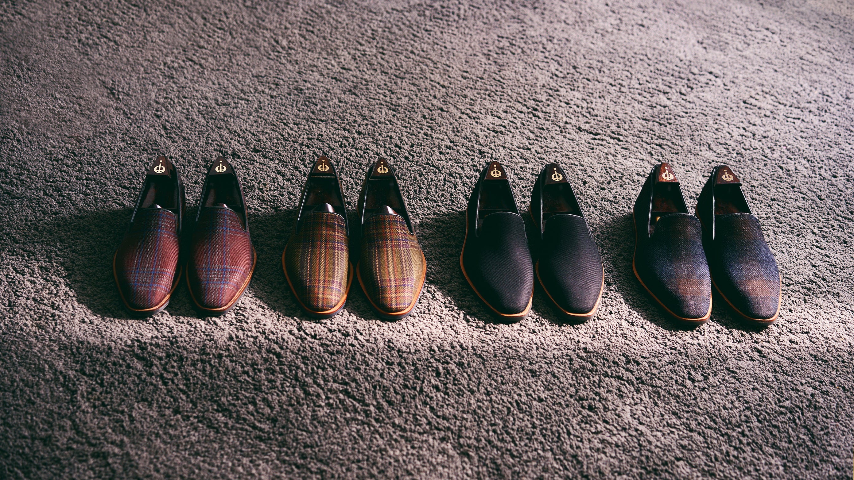 Set of six brown leather shoes arranged in a row on a textured surface