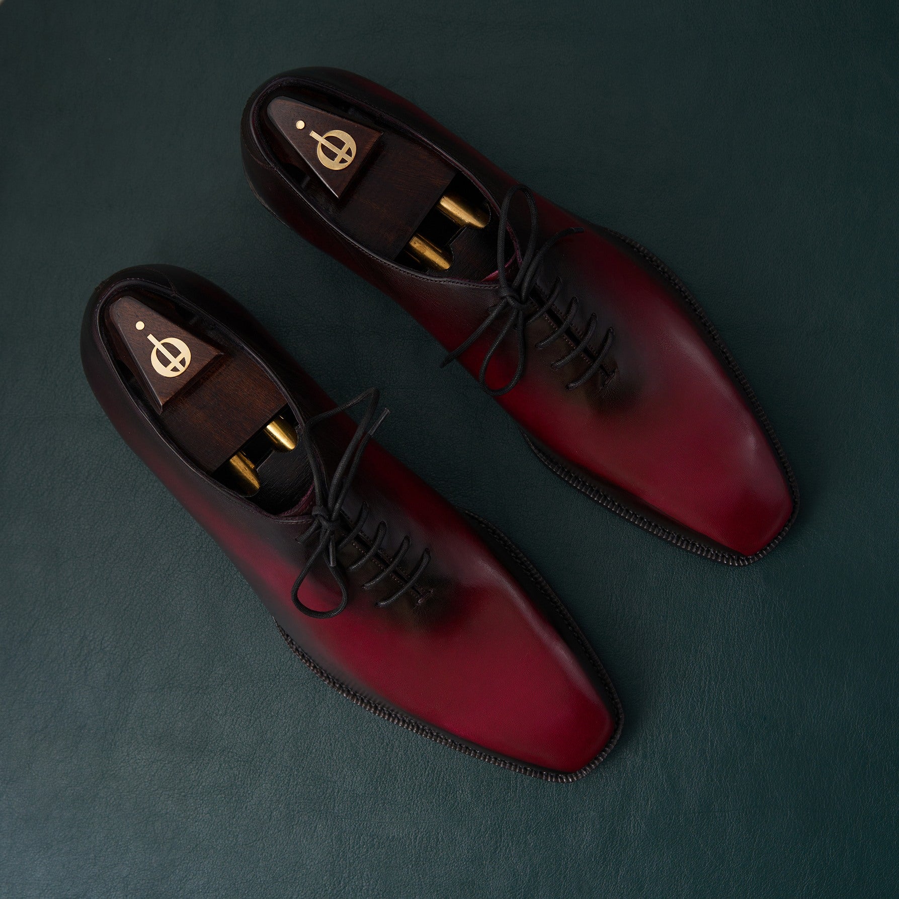 Pair of red and black dress shoes on a dark background
