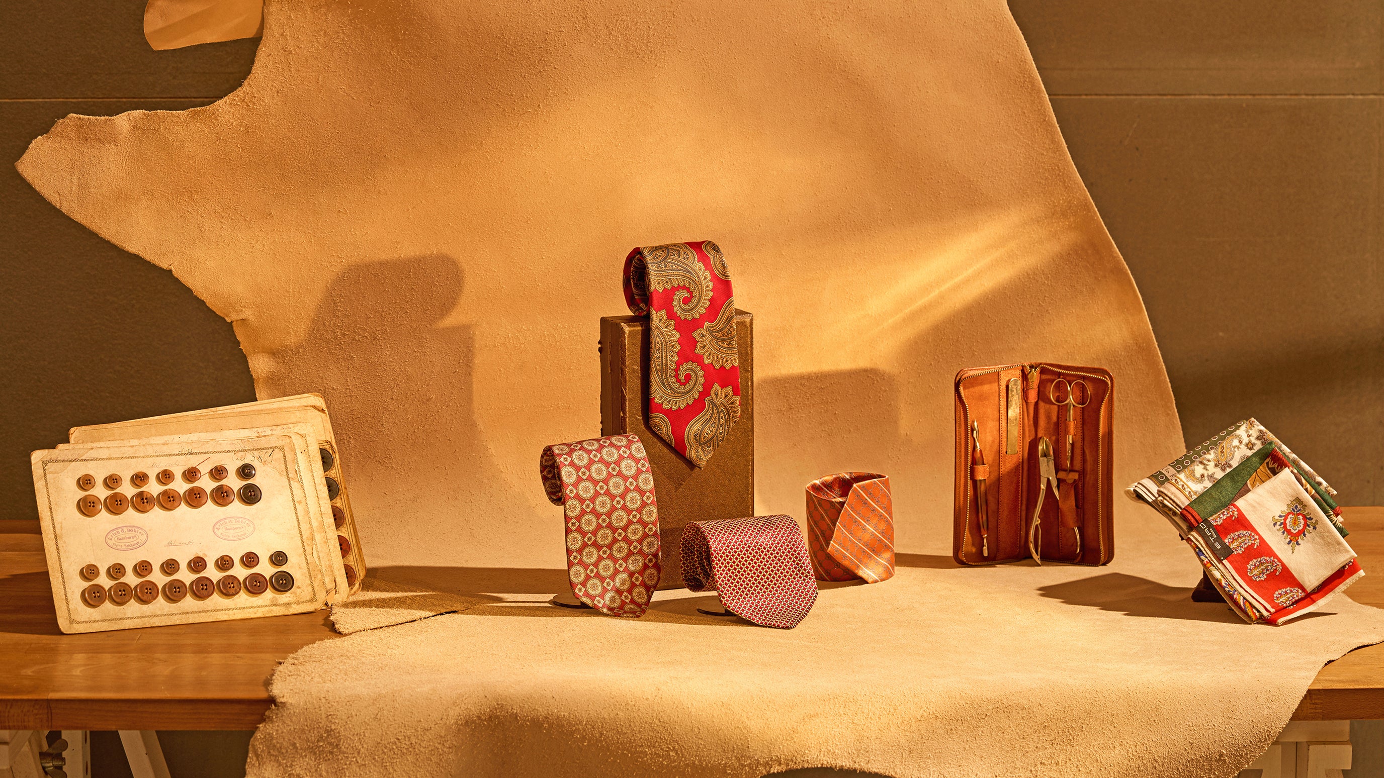 Collection of leather goods including wallets and a box on a wooden surface with a brown background.